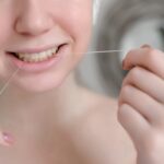 Woman flossing teeth properly to maintain healthy gums and daily oral hygiene routine
