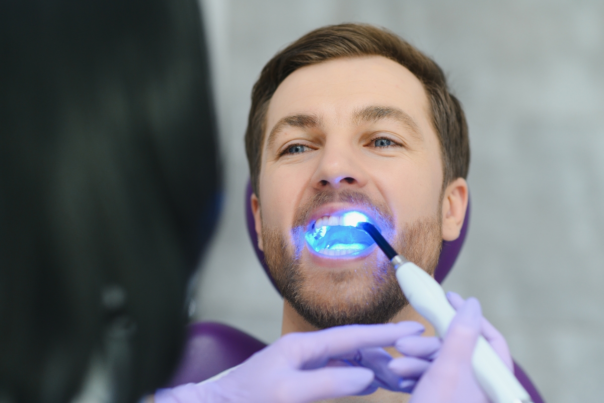 Patient receiving professional teeth whitening treatment with LED light