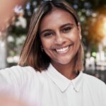 Woman smiling confidently after treatment for white spots on teeth