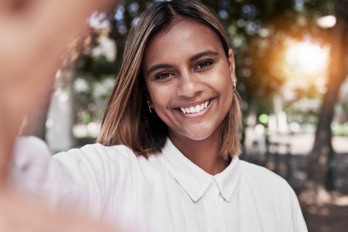 Woman smiling confidently after treatment for white spots on teeth